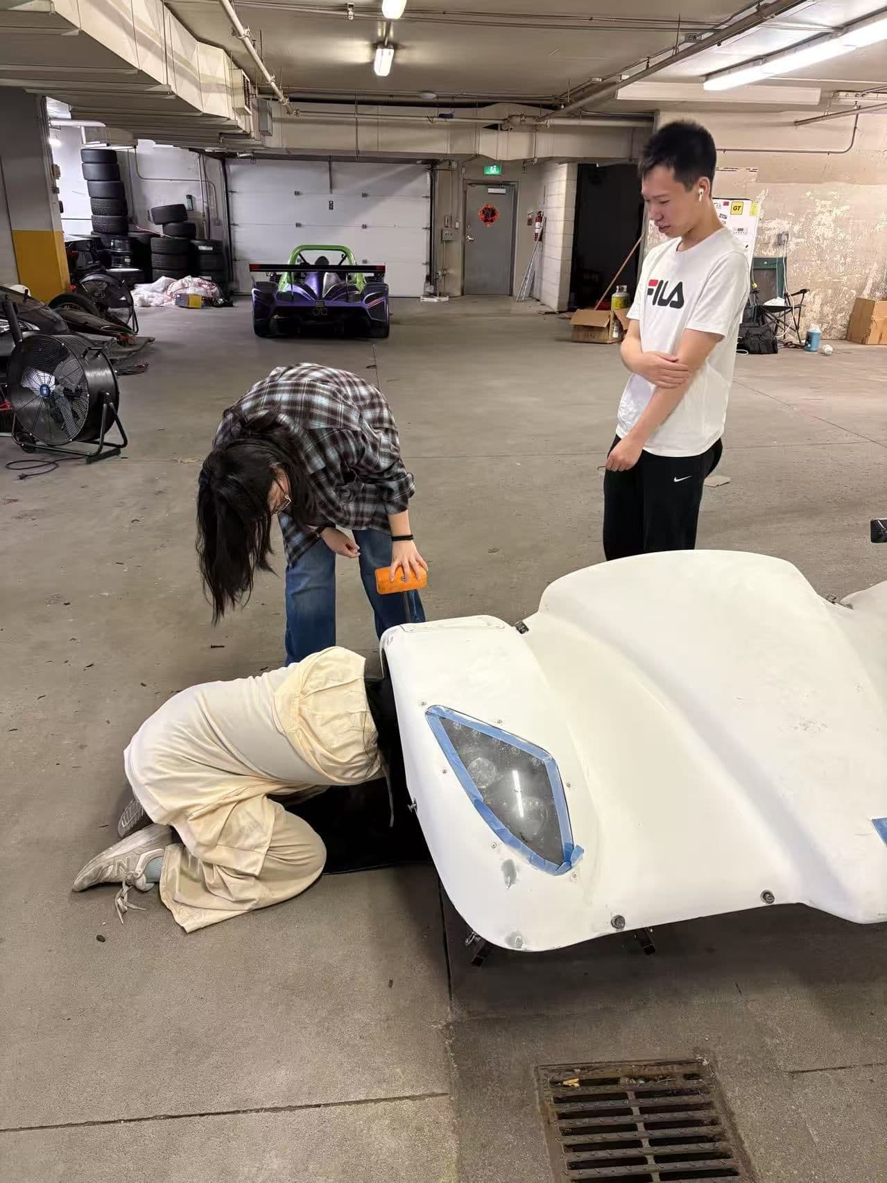 Students working on the EV body shell in the garage